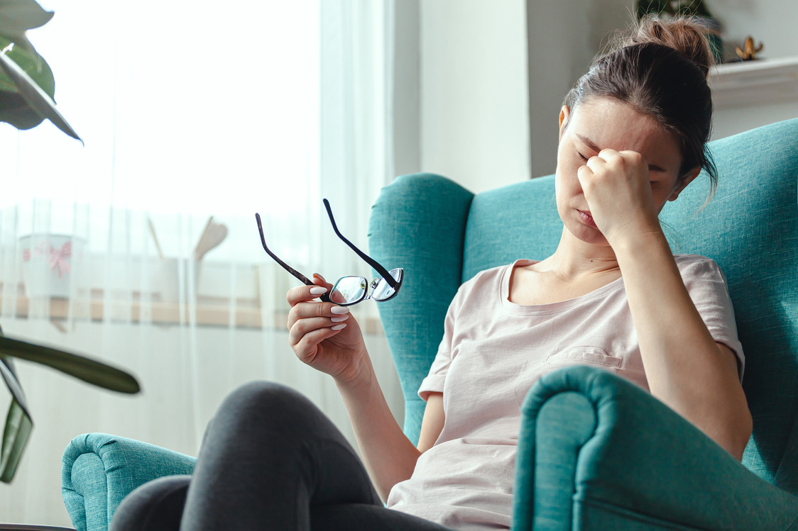 Young Woman with Eyeglasses Suffers Eye Fatigue